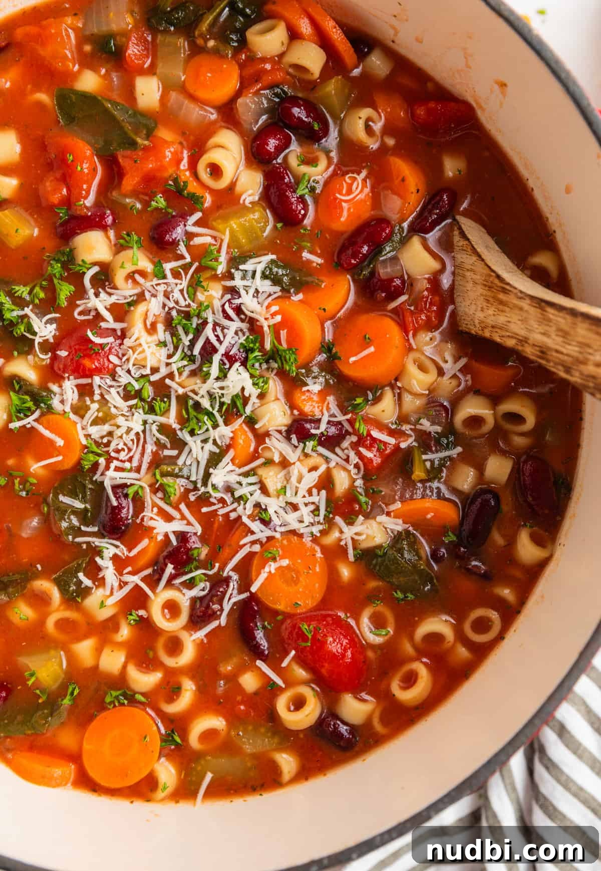 Hearty Chunky Italian Vegetable Soup Recipe 3 Overhead view of vegetable soup in dutch oven with ladle scooping in.