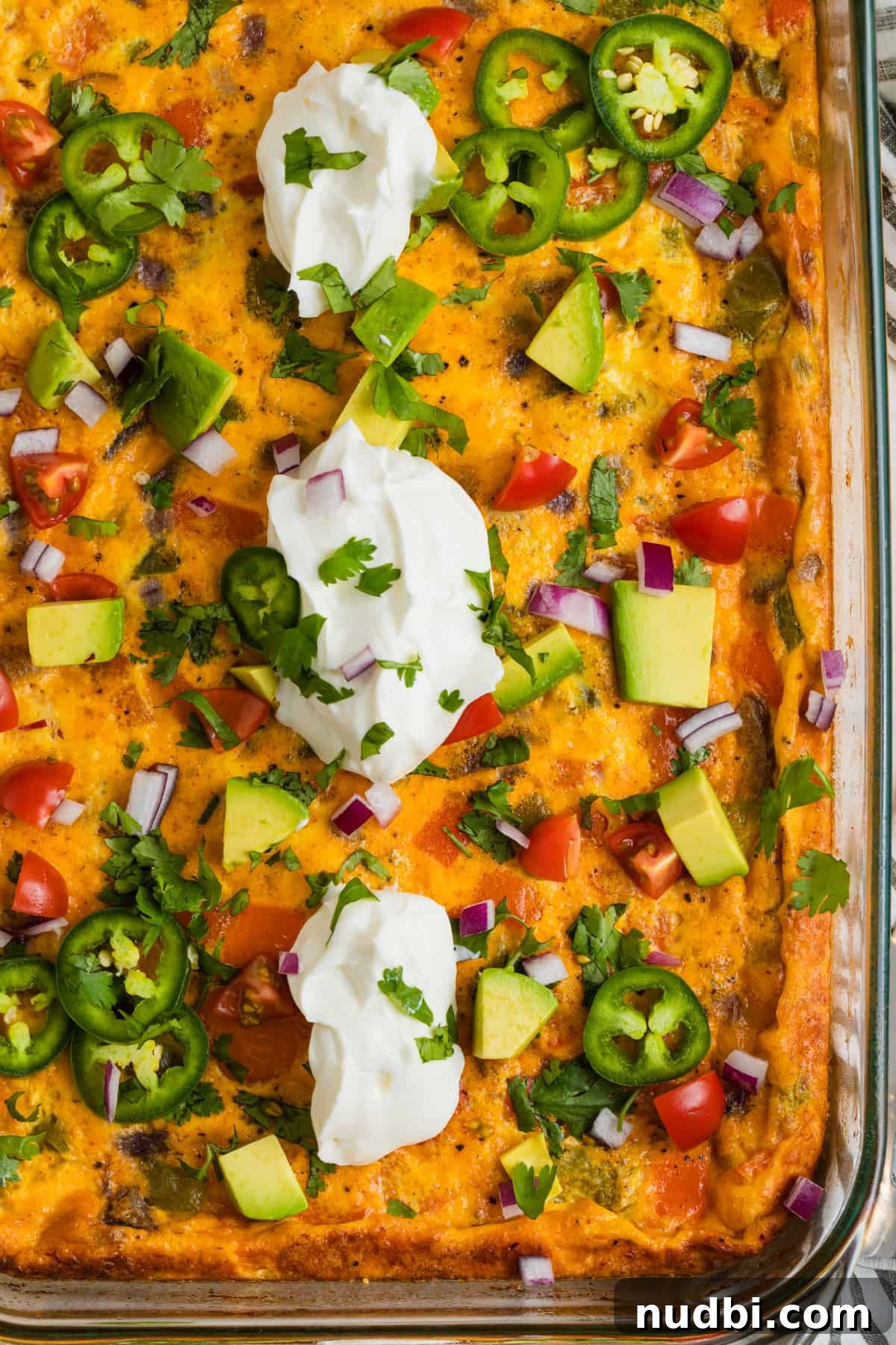 Cheesy Chorizo and Egg Breakfast Casserole 2 Chorizo egg bake in pan topped with sour cream, cilantro, tomatoes, avocado, etc.