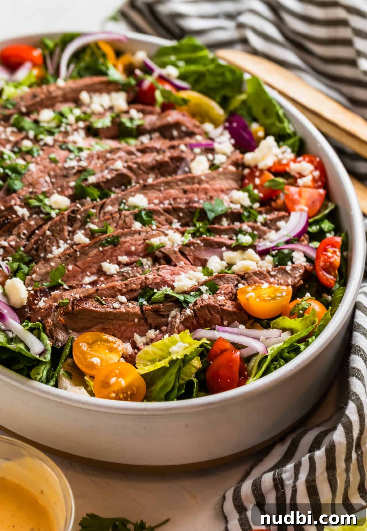 Grilled Flank Steak Salad with Chimichurri and Arugula 2 Grilled flank steak salad topped with chopped cilantro and cheese.