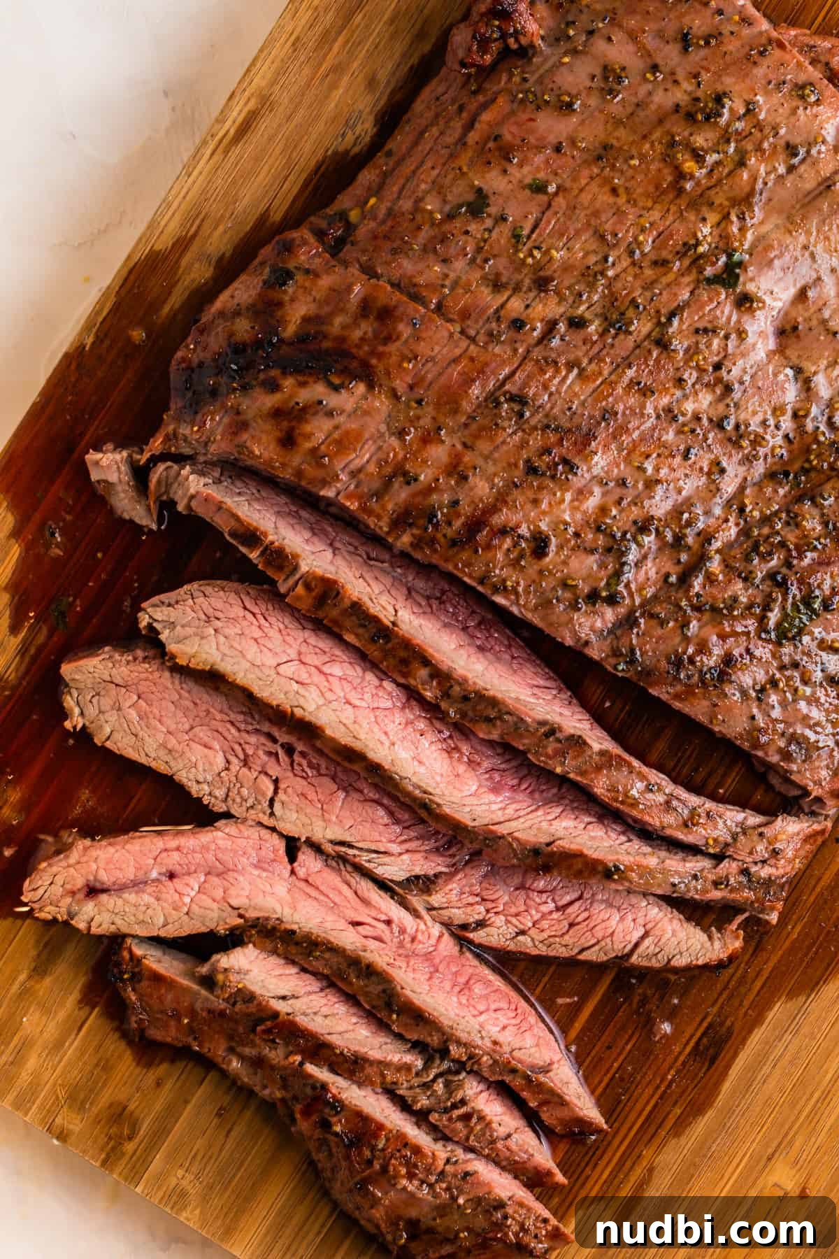Grilled Flank Steak Salad with Chimichurri and Arugula 9 Sliced flank steak on cutting board with juices.