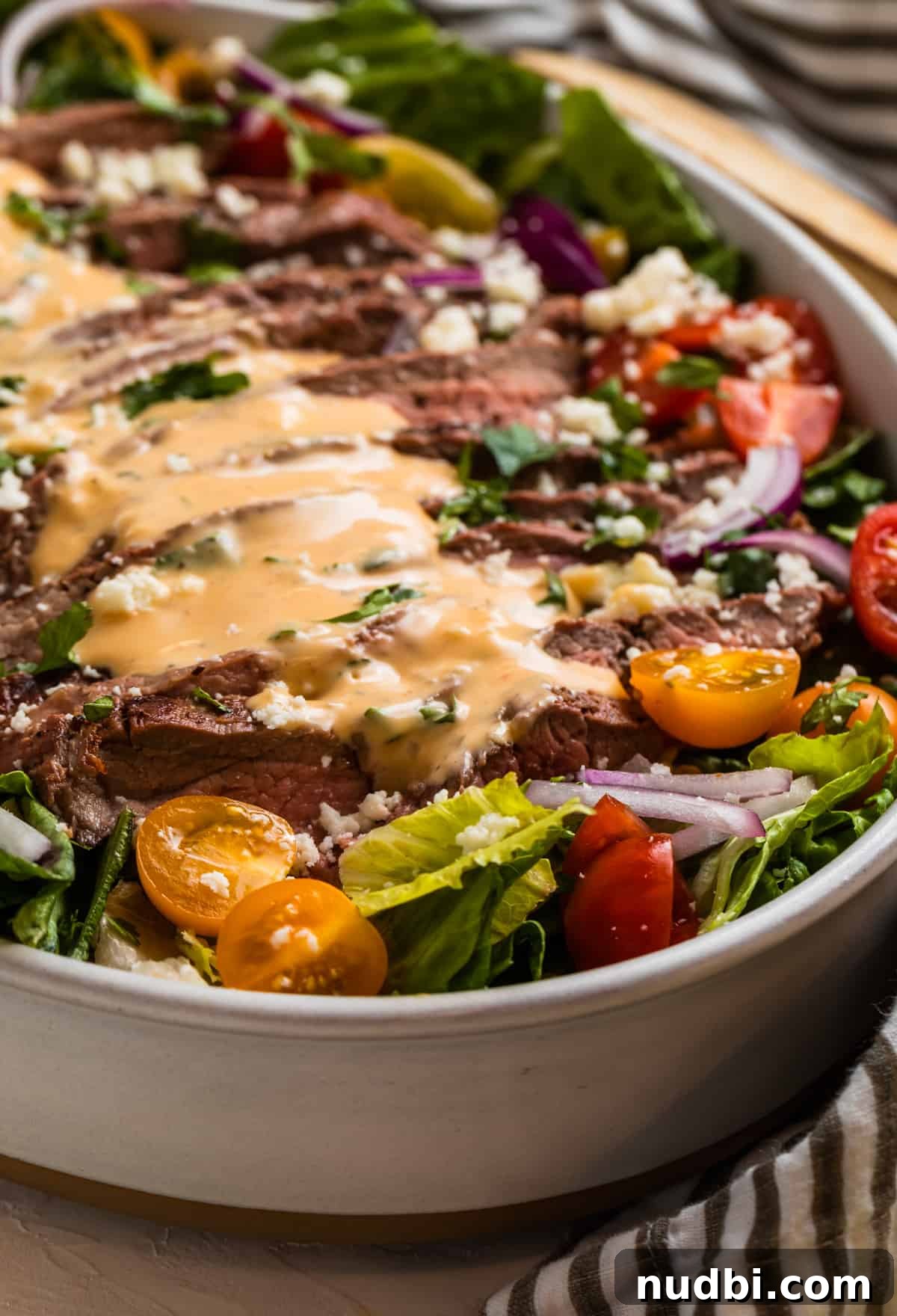 Grilled Flank Steak Salad with Chimichurri and Arugula 10 Sliced grilled steak on lettuce greens with spicy dressing over top.
