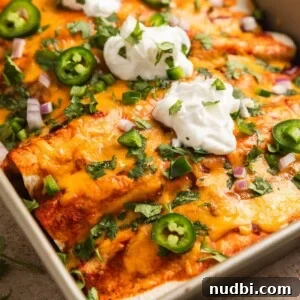 Cheesy Ground Turkey Enchiladas with Homemade Red Sauce 13 Ground turkey enchiladas in baking pan topped with sour cream, cilantro, onion and jalapeño.