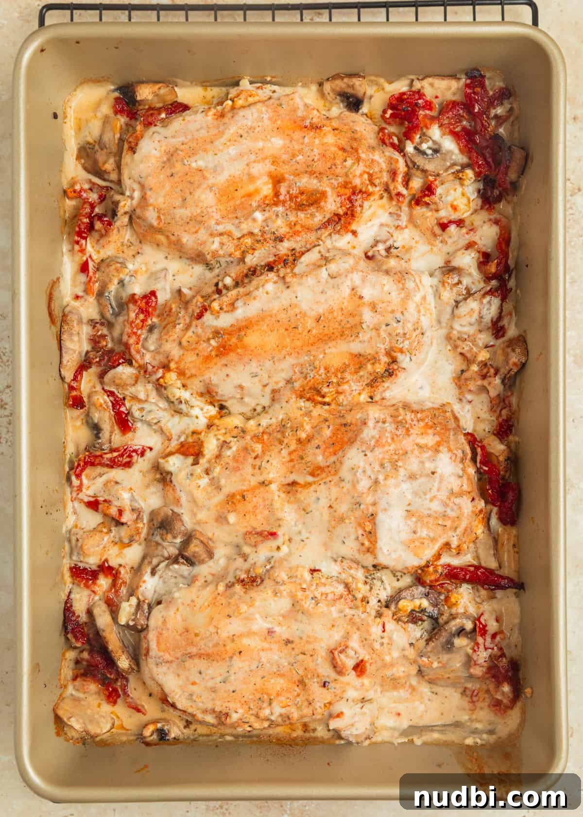 Creamy Baked Tuscan Chicken with Sun-Dried Tomatoes and Spinach 9 Baked tuscan chicken in pan with creamy sauce over top.