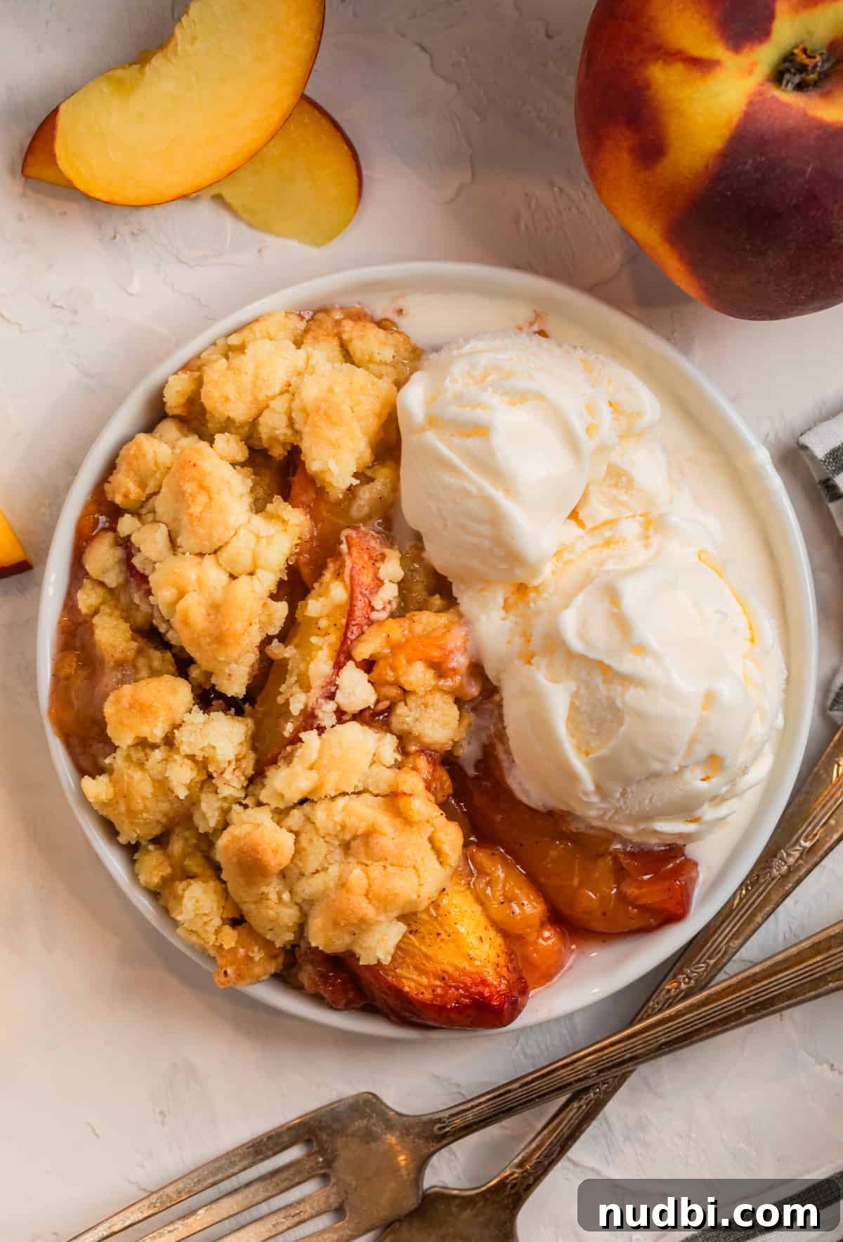 Peach Cobbler Made with Cake Mix: Quick Southern Dessert recipe 2 Peach cobbler made with cake mix on white plate with vanilla ice cream scoops.
