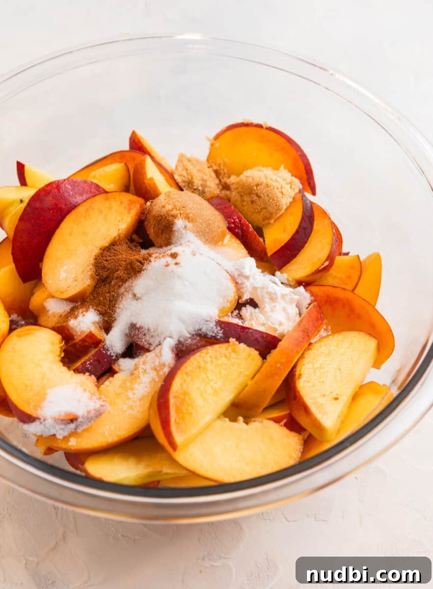 Peach Cobbler Made with Cake Mix: Quick Southern Dessert recipe 4 Sliced peaches, cinnamon, sugar, cornstarch and lemon juice in glass mixing bowl.