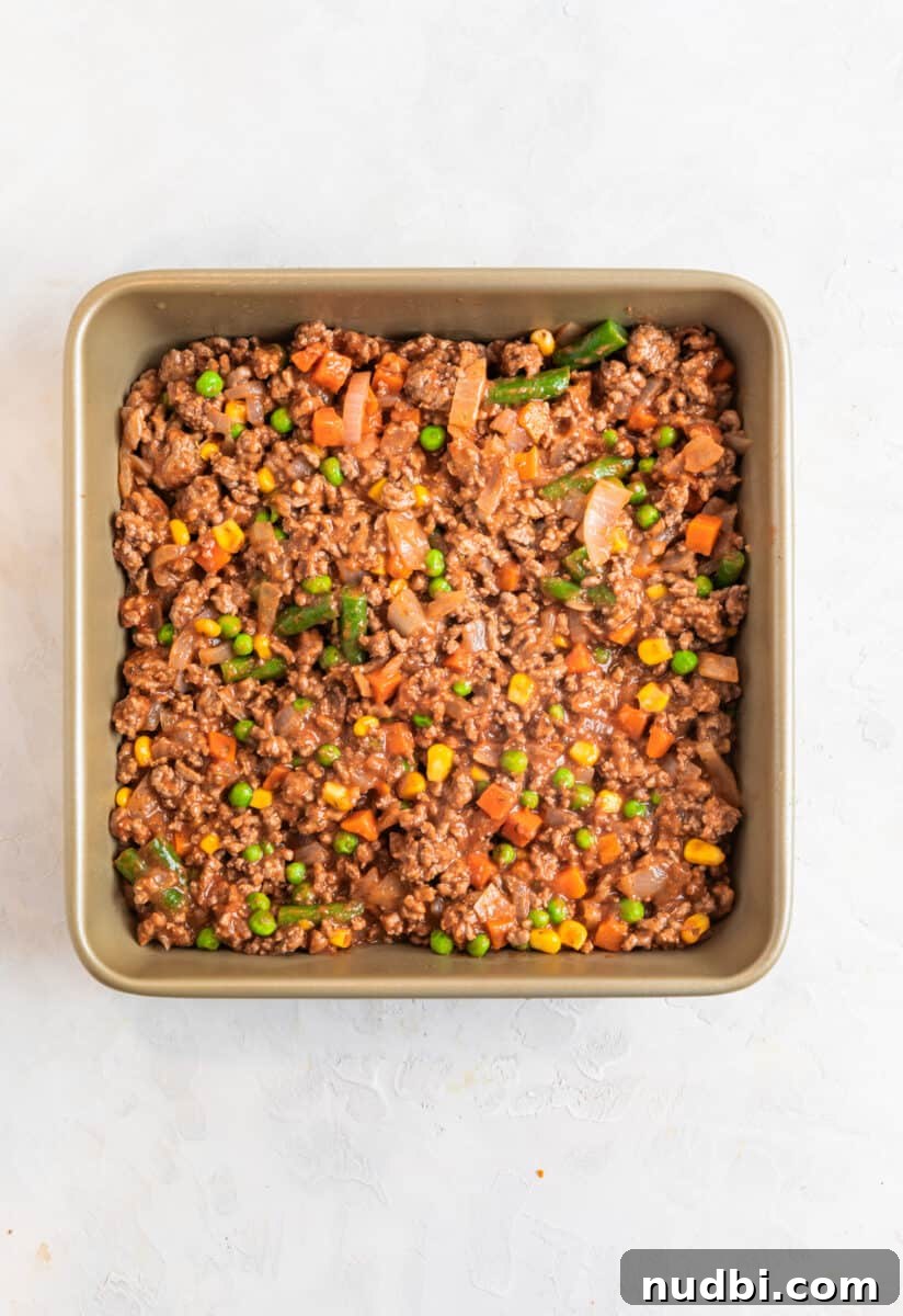 Tater Tot Shepherd’s Pie Recipe: Comforting Family Meal 7 Beef and vegetable mixture in baking pan.