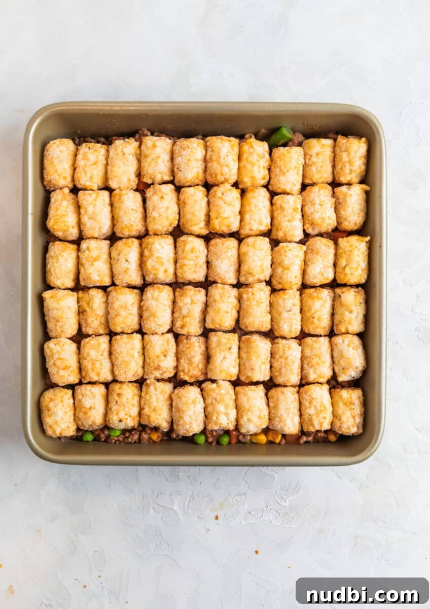 Tater Tot Shepherd’s Pie Recipe: Comforting Family Meal 8 Tater tots lined over beef mixture in baking pan.