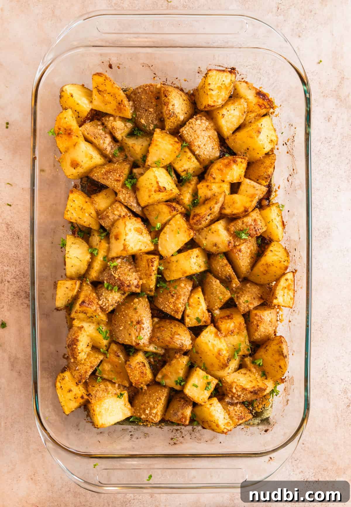 Crispy Parmesan-Crusted Potatoes with Garlic and Herbs 7 Roasted parmesan crusted potatoes in glass pan.