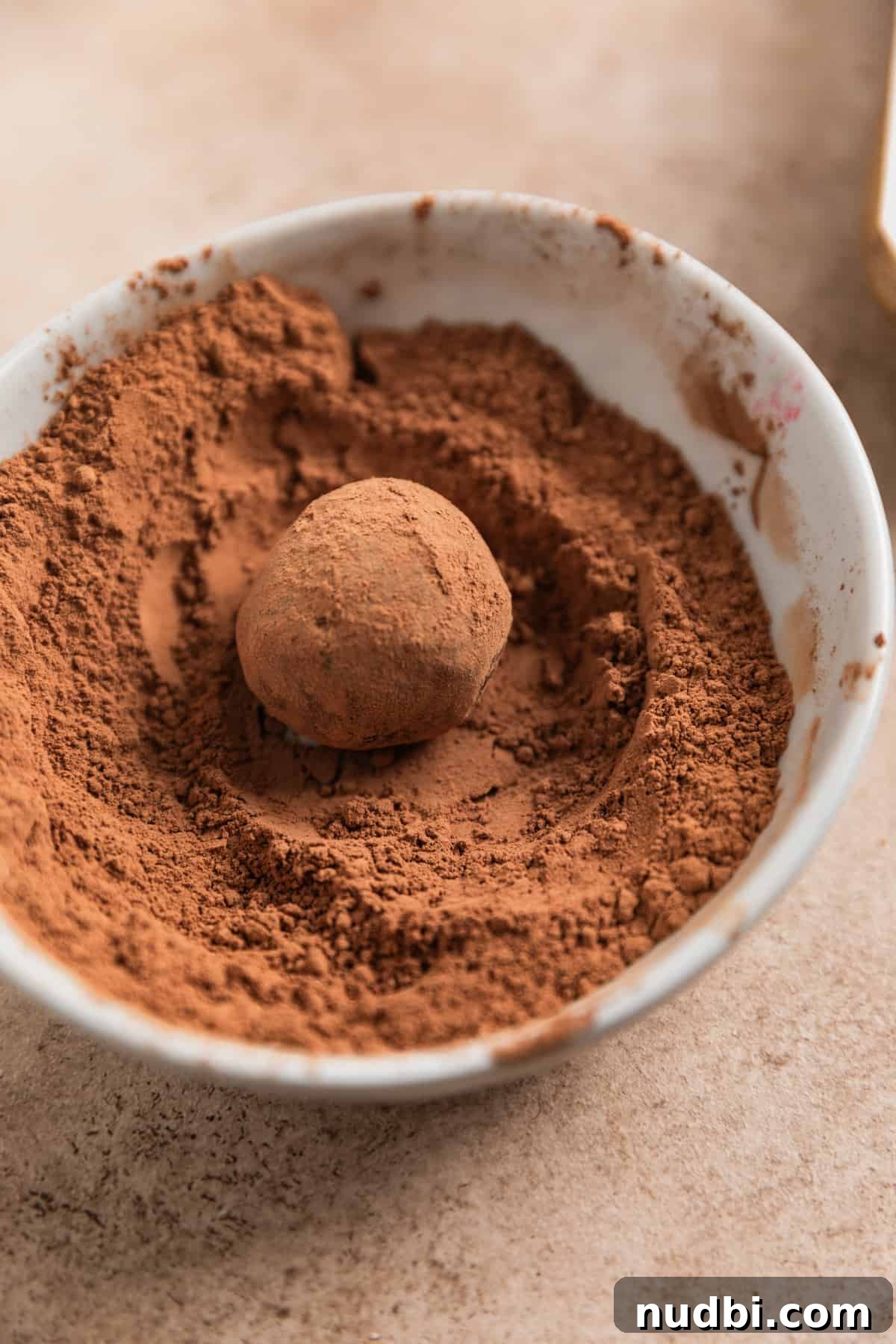 Amaretto Truffles Recipe with 5 Ingredients — Simple Chocolate Bonbons 10 Amaretto truffle in bowl with cocoa powder.