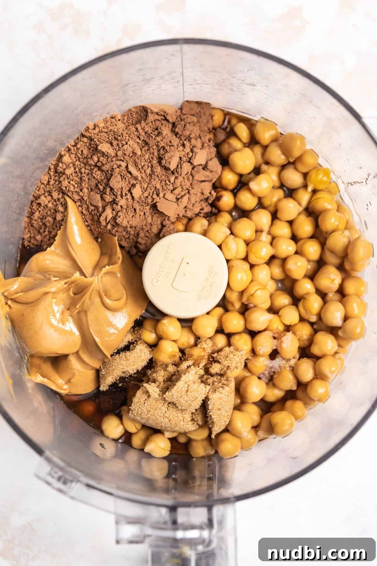 Decadent Brownie Batter Hummus Recipe: Dessert Dip Made Vegan 4 Garbanzo beans, cocoa powder, peanut butter, maple and other ingredients in food processor.