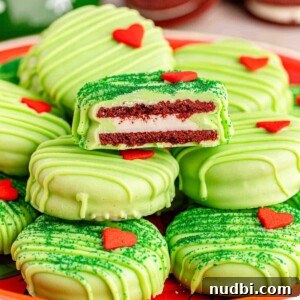 Red velvet Oreos dipped in green candy coating and decorated with a candy heart.