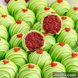 Red velvet Grinch Oreo balls on white plate with bite taken out of several.