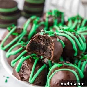 Mint chocolate truffles coated in chocolate and green drizzle over top.