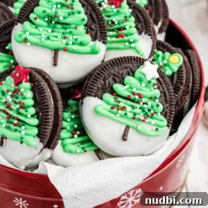 Chocolate sandwich cookies with Christmas trees iced onto each.