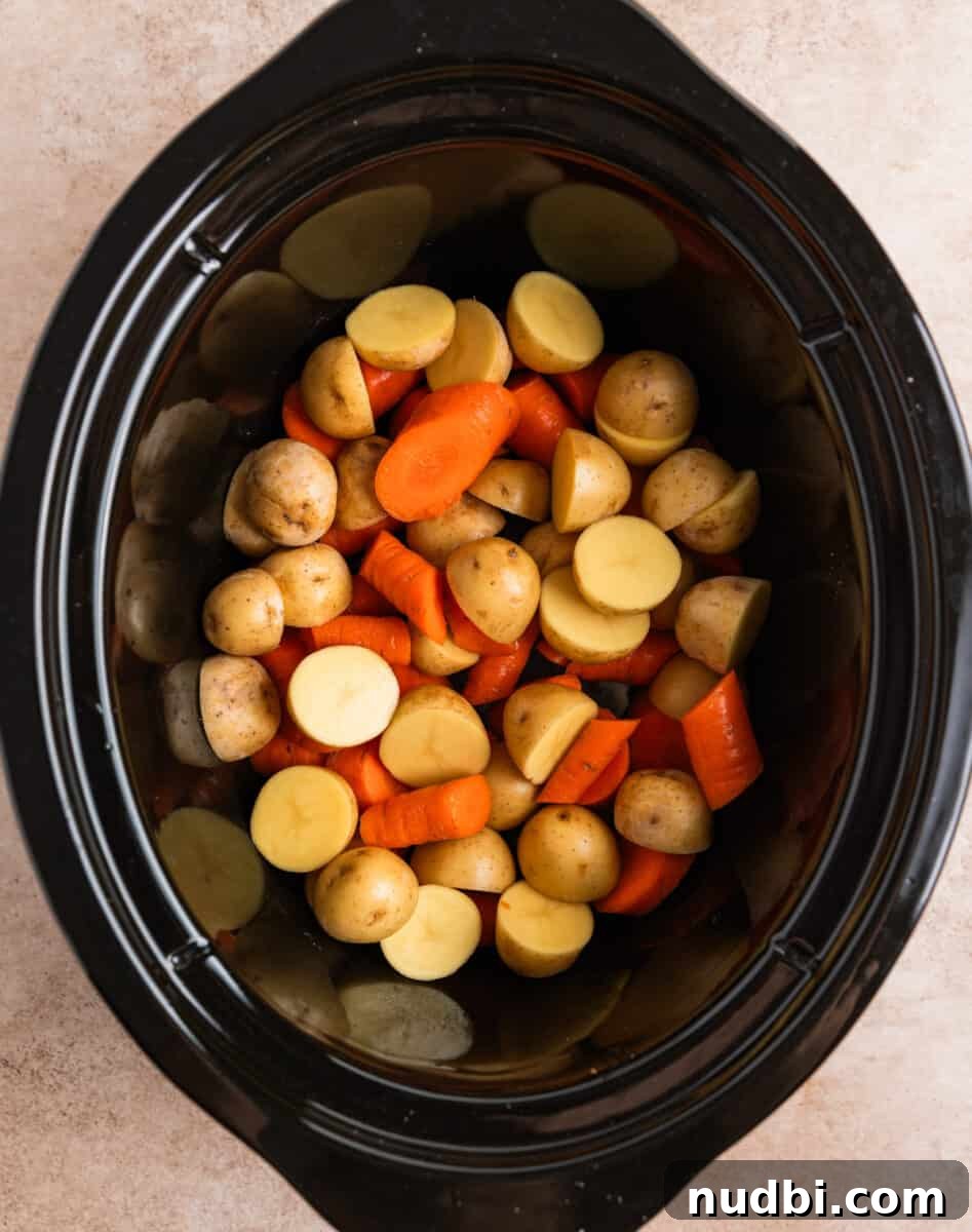 Slow Cooker Beef and Mushroom Stew Recipe for Tender Comfort Food 7 Carrots and potatoes chopped and placed in bottom of crockpot.