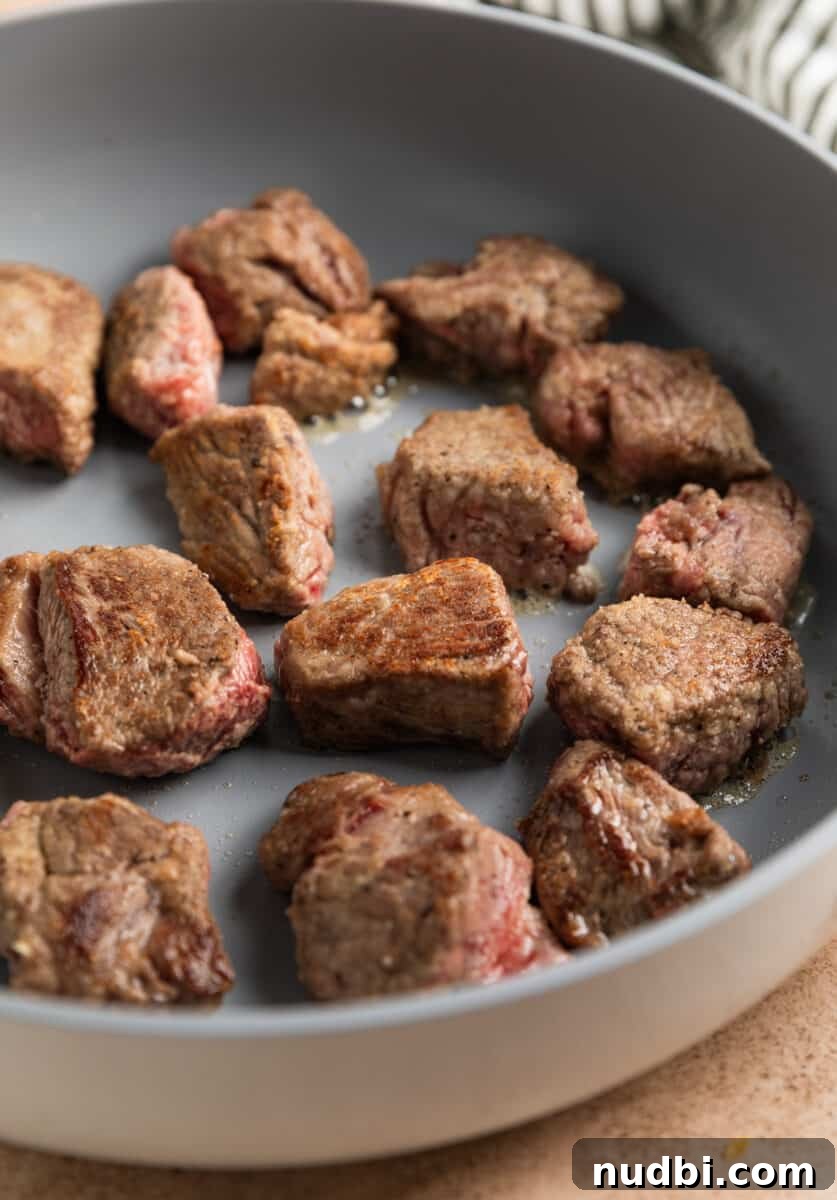Slow Cooker Beef and Mushroom Stew Recipe for Tender Comfort Food 8 Seared cubed beef stew in skillet.