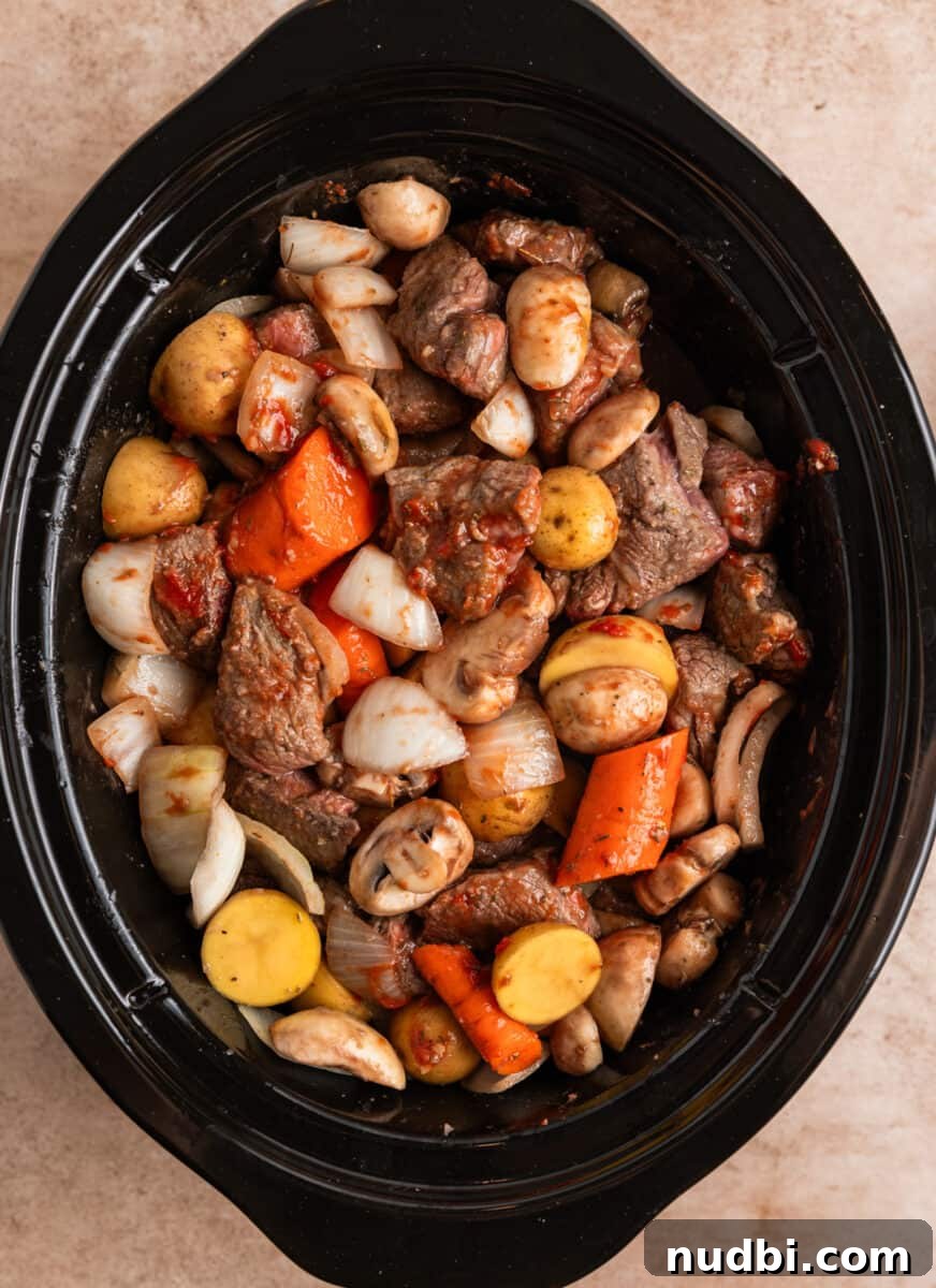 Slow Cooker Beef and Mushroom Stew Recipe for Tender Comfort Food 10 Slow cooker filled with beef mushroom stew ingredients.