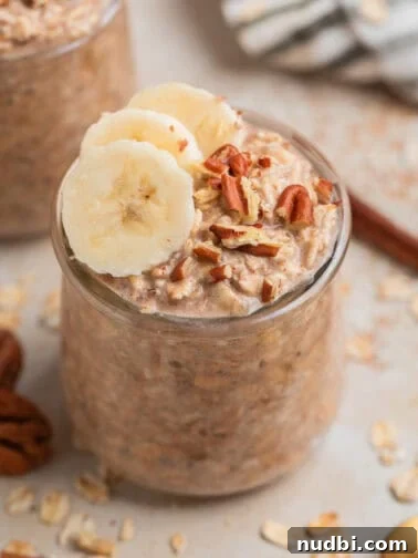 Glass jar with overnight oatmeal topped with bananas and nuts.