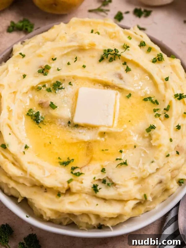 Juicy Slow Cooker Turkey Breast Recipe 17 Garlic parmesan mashed potatoes in serving dish with melted butter over top.