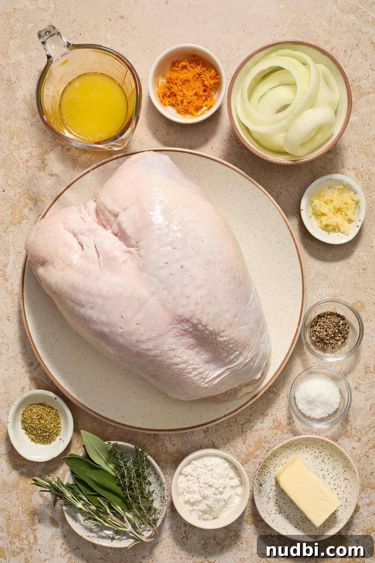Juicy Slow Cooker Turkey Breast Recipe 4 Butter, flour, herbs, orange zest, turkey breast and other ingredients arranged on surface.