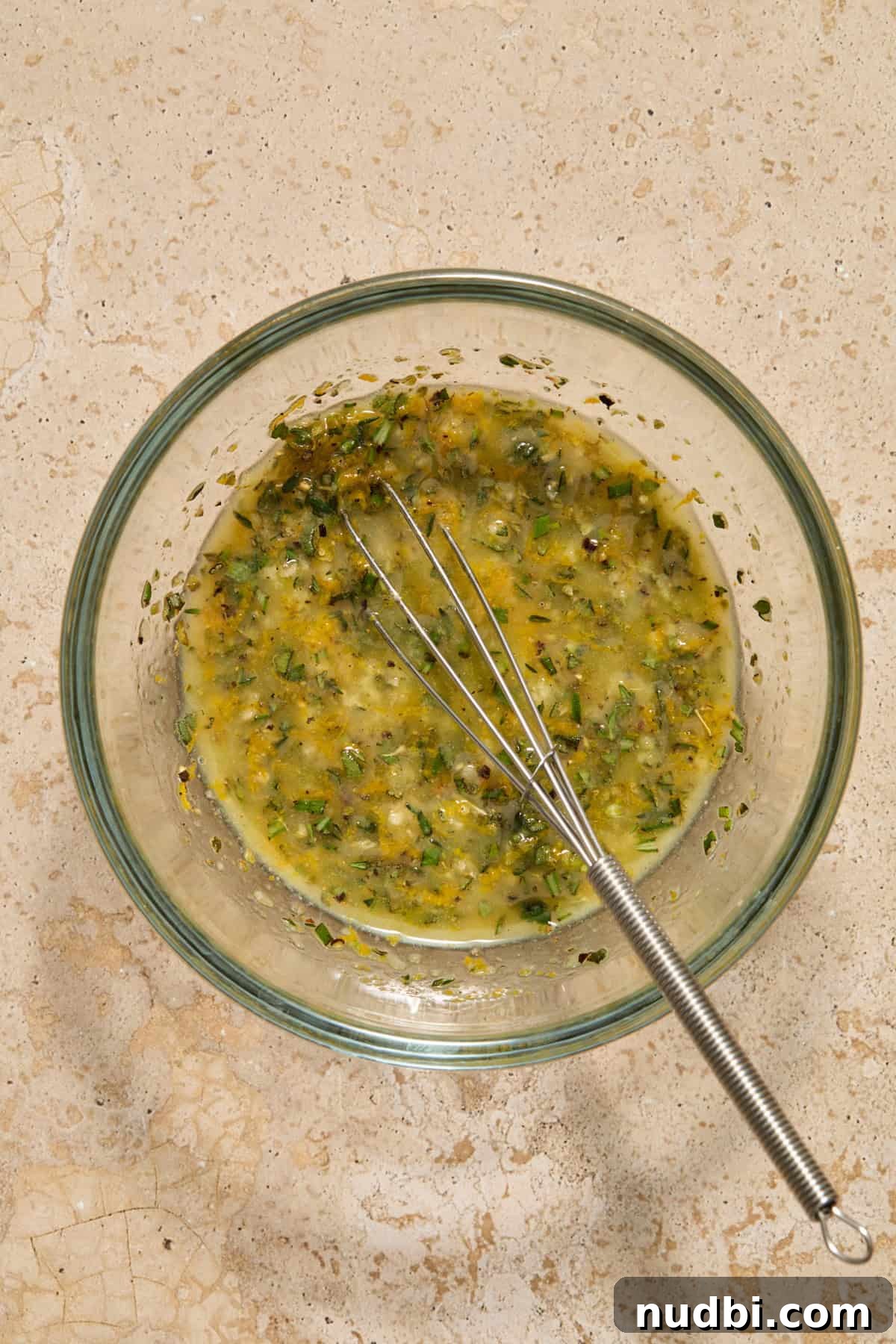Juicy Slow Cooker Turkey Breast Recipe 5 Herbs and butter whisked in small bowl with whisk propped.