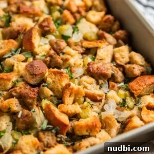 Turkey Sausage Stuffing Recipe for Thanksgiving and Holiday Meals 21 Turkey sausage sourdough bread stuffing in pan with fresh herbs on top.