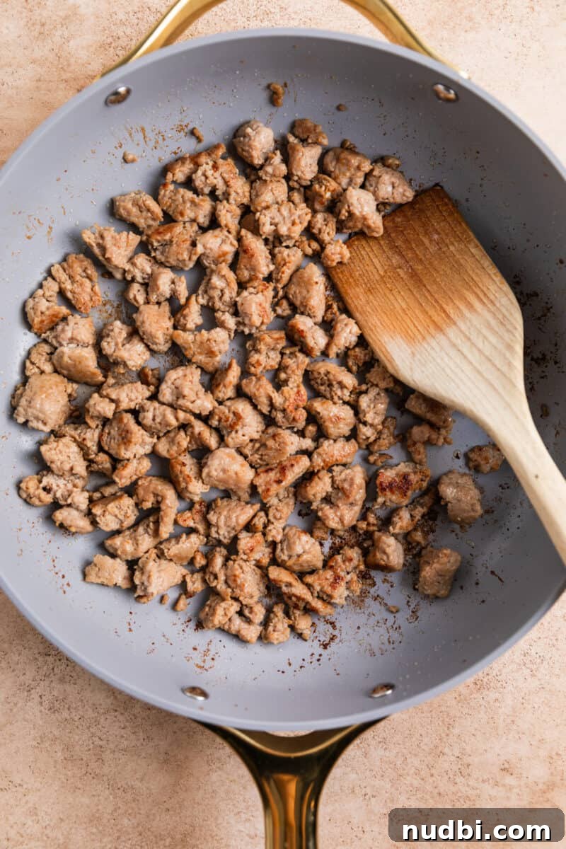 Turkey Sausage Stuffing Recipe for Thanksgiving and Holiday Meals 7 Browned turkey sausage in skillet with wooden spoon.