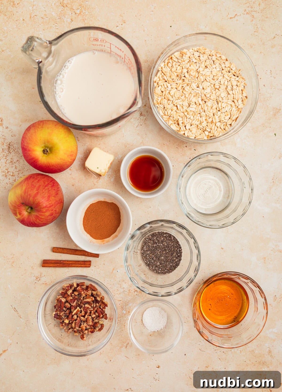 Apple Cinnamon Overnight Oats Recipe for Quick Breakfast 4 Apples, milk, maple syrup, and other ingredients laid out for recipe.