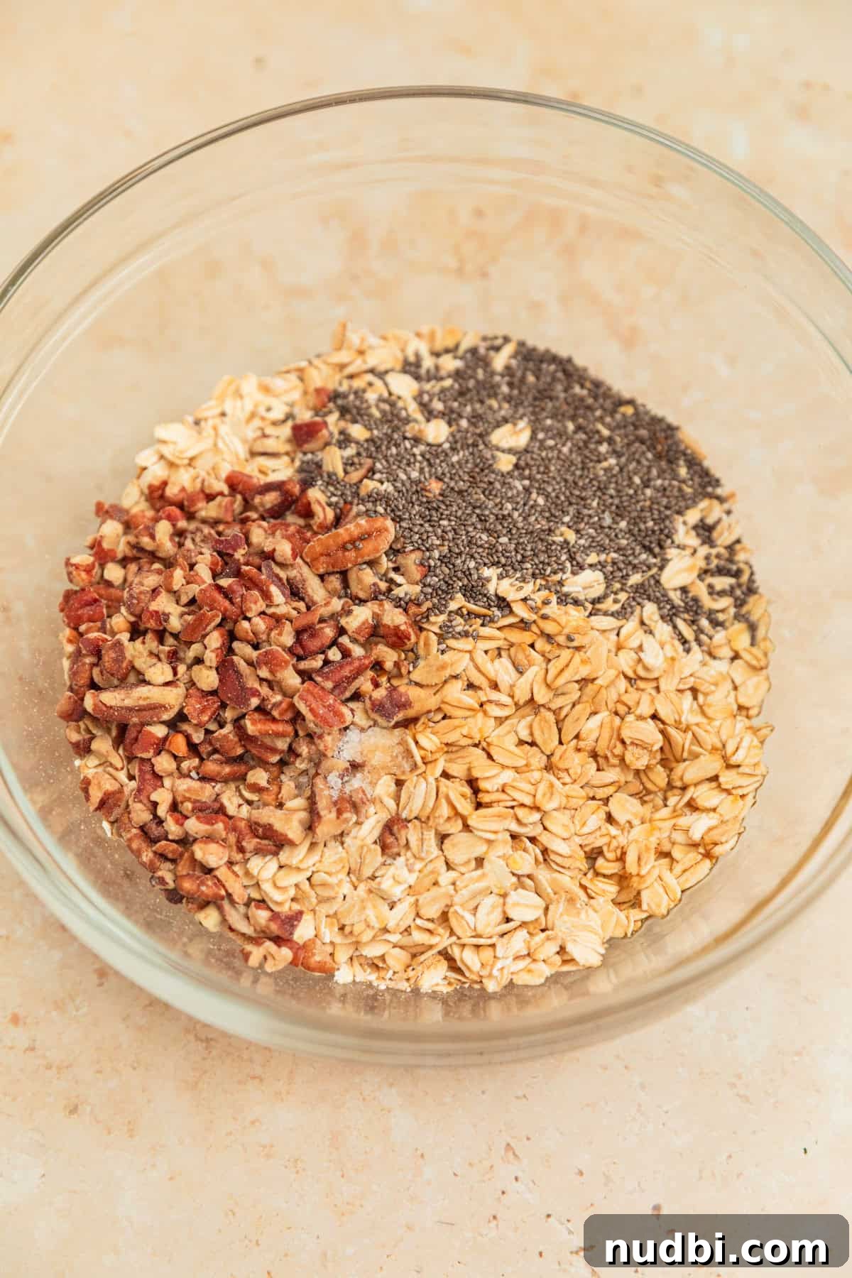 Apple Cinnamon Overnight Oats Recipe for Quick Breakfast 7 Old fashioned oats, chia seeds, pecans and other ingredients in mixing bowl.