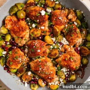 Sheet Pan Chicken Thighs with Roasted Brussels Sprouts 15 Overhead view of pan with cooked chicken thighs and brussel sprouts topped with goat cheese.