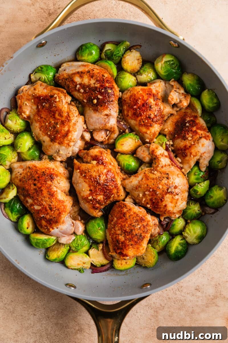 Sheet Pan Chicken Thighs with Roasted Brussels Sprouts 8 Chicken and vegetables in skillet with balsamic vinegar, mixture poured over.