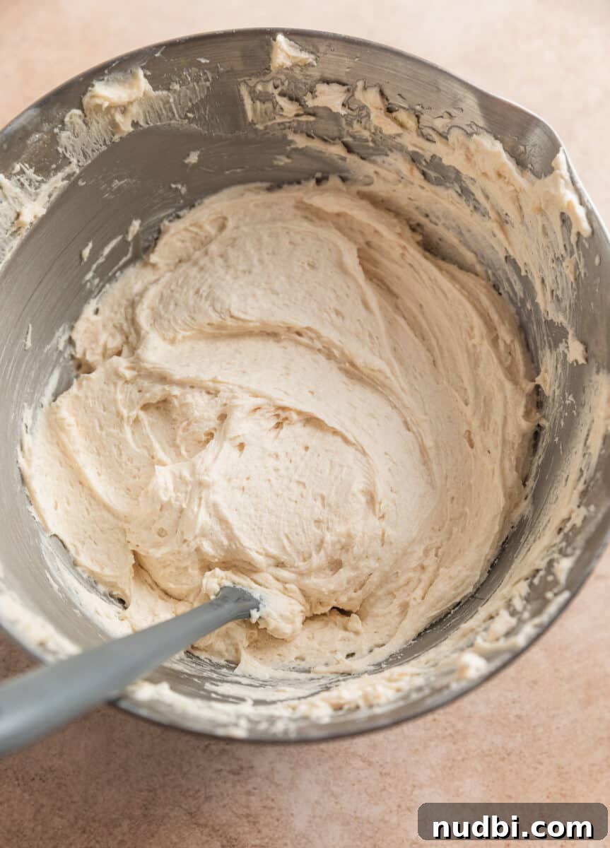 Chewy Ginger Cream Cookie Recipe for Perfect Holiday Baking 13 Finished brown sugar buttercream frosting in mixing bowl with spatula.