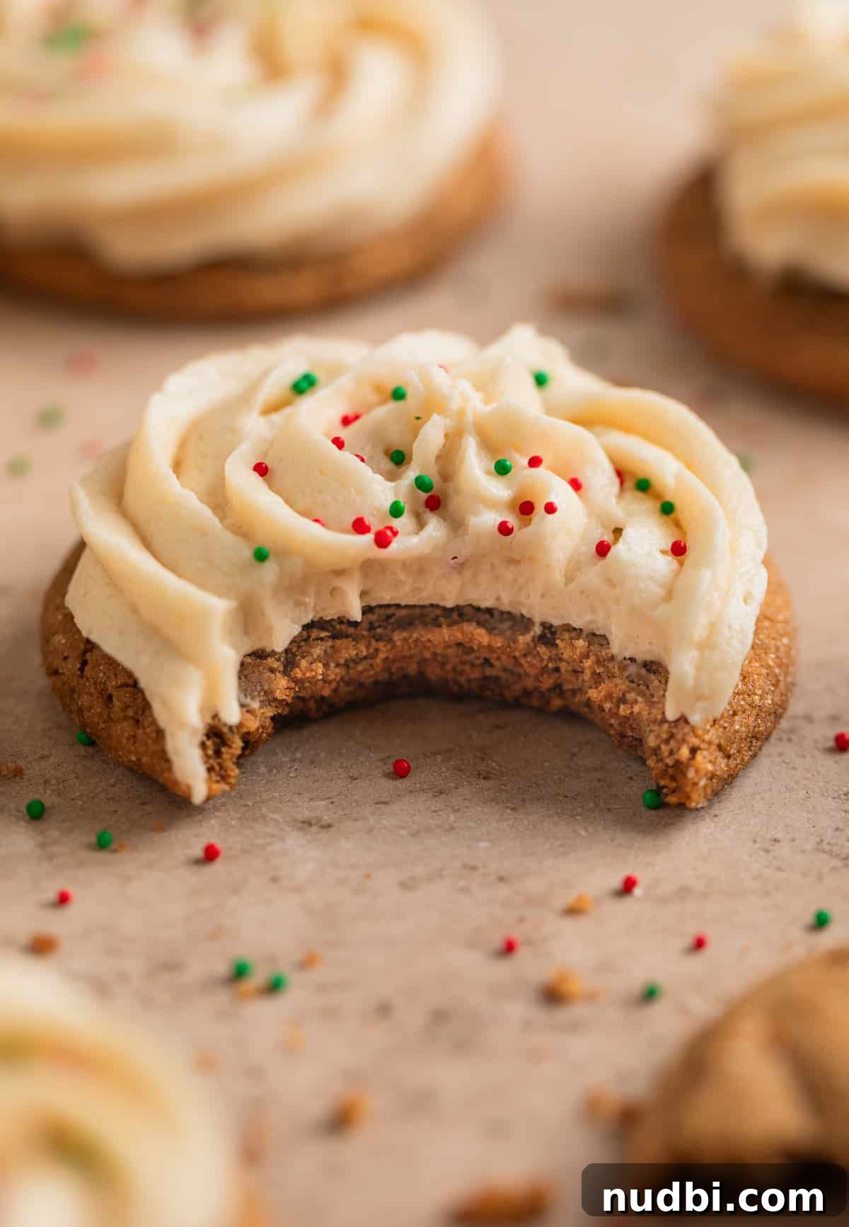 Chewy Ginger Cream Cookie Recipe for Perfect Holiday Baking 3 Bite taken out of cookie with icing on top.