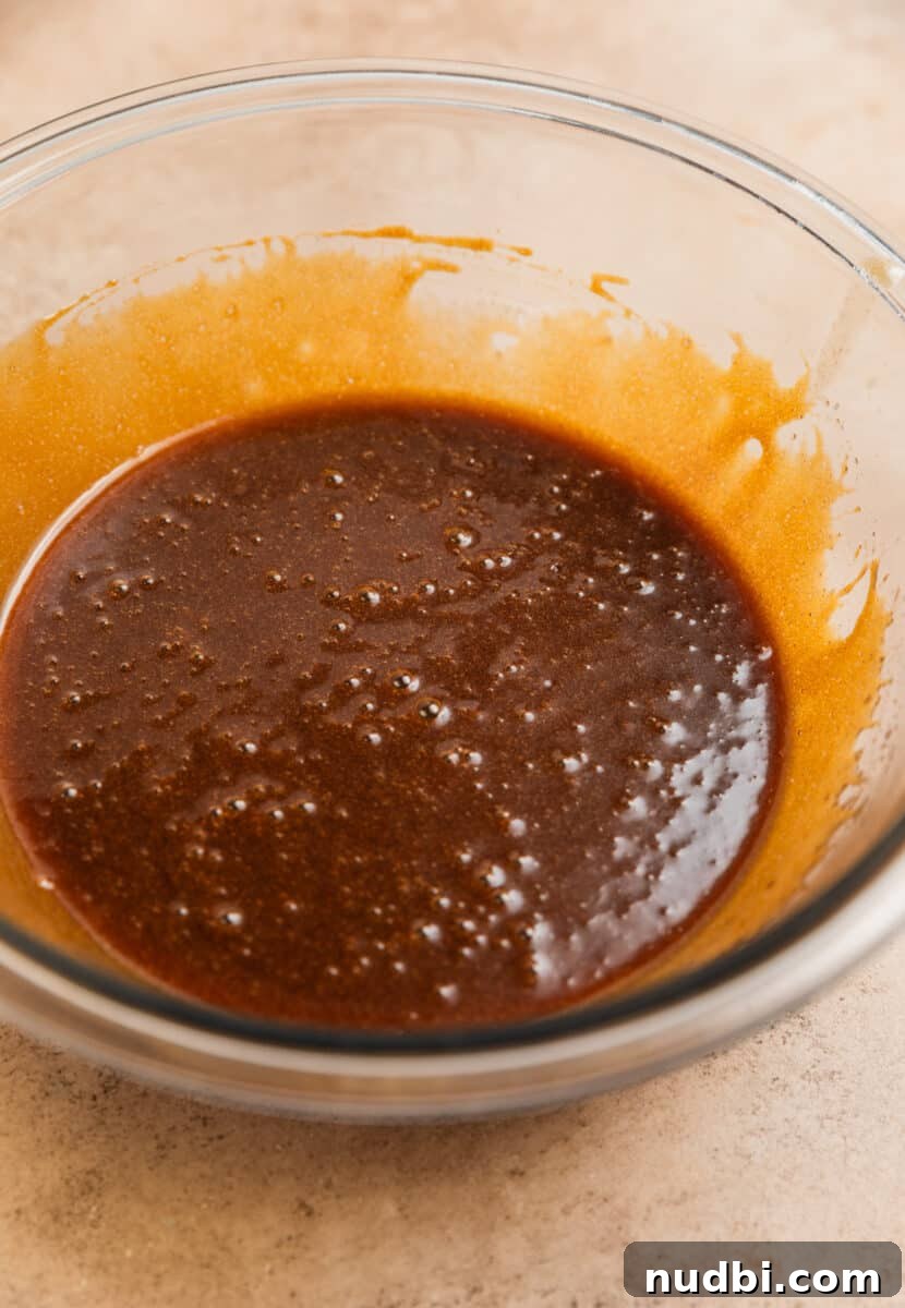 Chewy Ginger Cream Cookie Recipe for Perfect Holiday Baking 6 Molasses added to glass mixing bowl with ginger cookie ingredients.