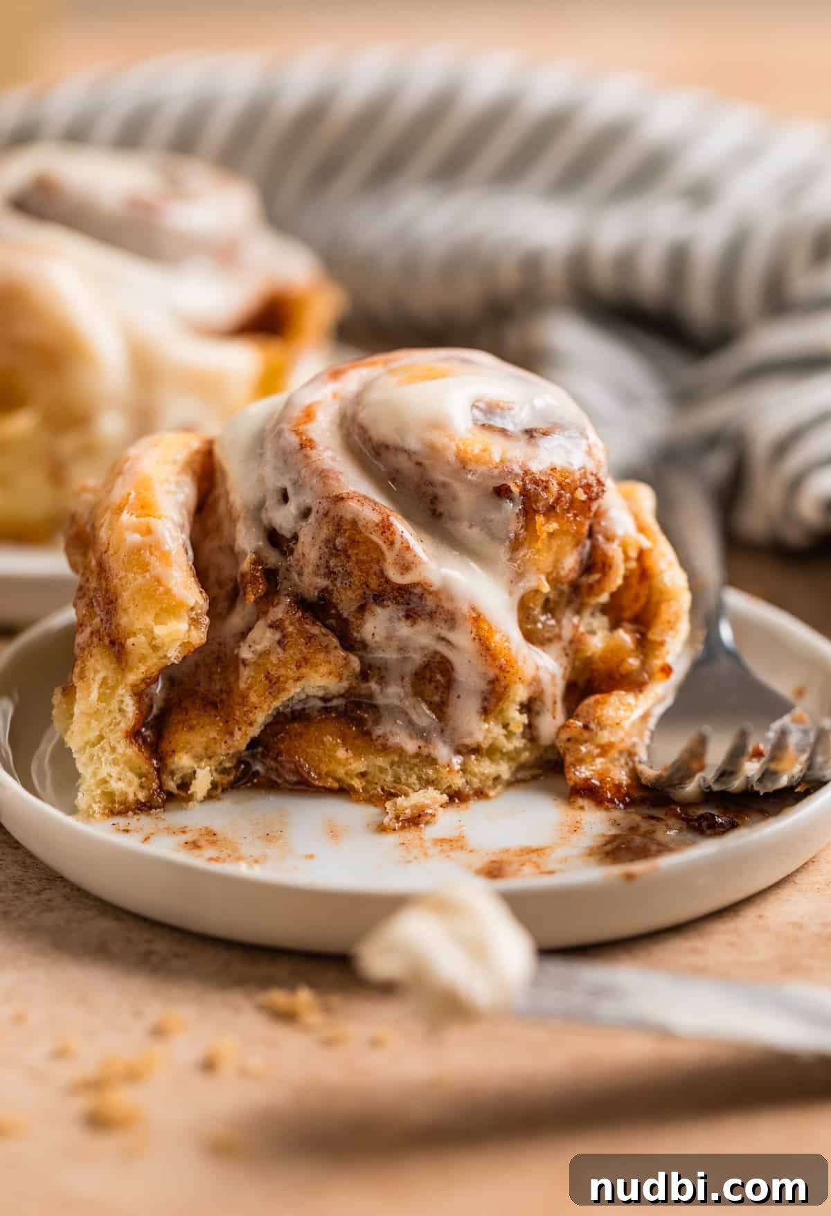 Fluffy Buttermilk Cinnamon Rolls from Scratch 22 Buttermilk cinnamon roll cut into on a white plate.