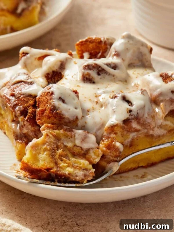 Fluffy Buttermilk Cinnamon Rolls from Scratch 24 Slice of Brioche French toast bake with cinnamon and cream cheese frosting on plate.