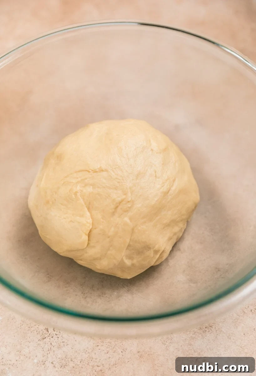 Fluffy Buttermilk Cinnamon Rolls from Scratch 9 Buttermilk cinnamon roll dough ball in glass bowl before rising.