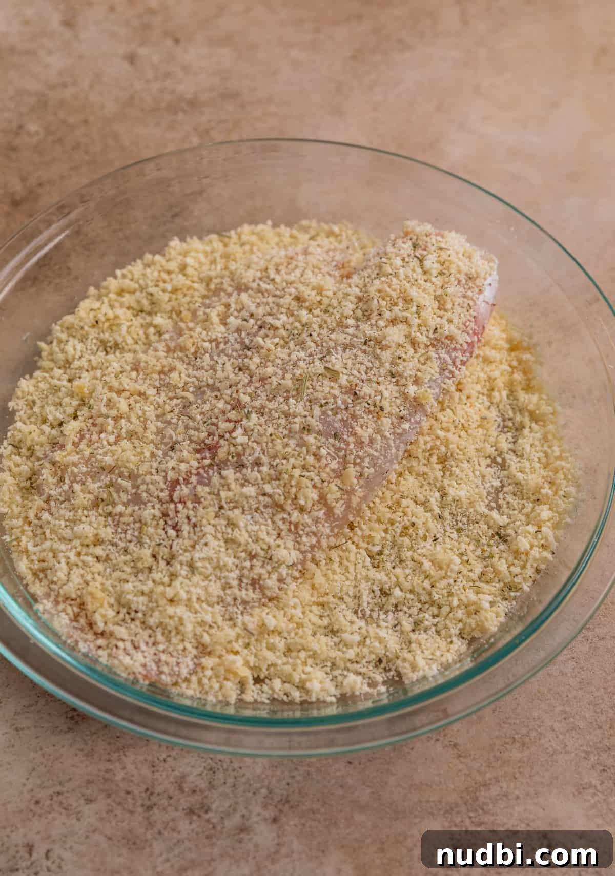 Crispy Parmesan-Crusted Tilapia in the Air Fryer 5 Coated tilapia in glass dish.