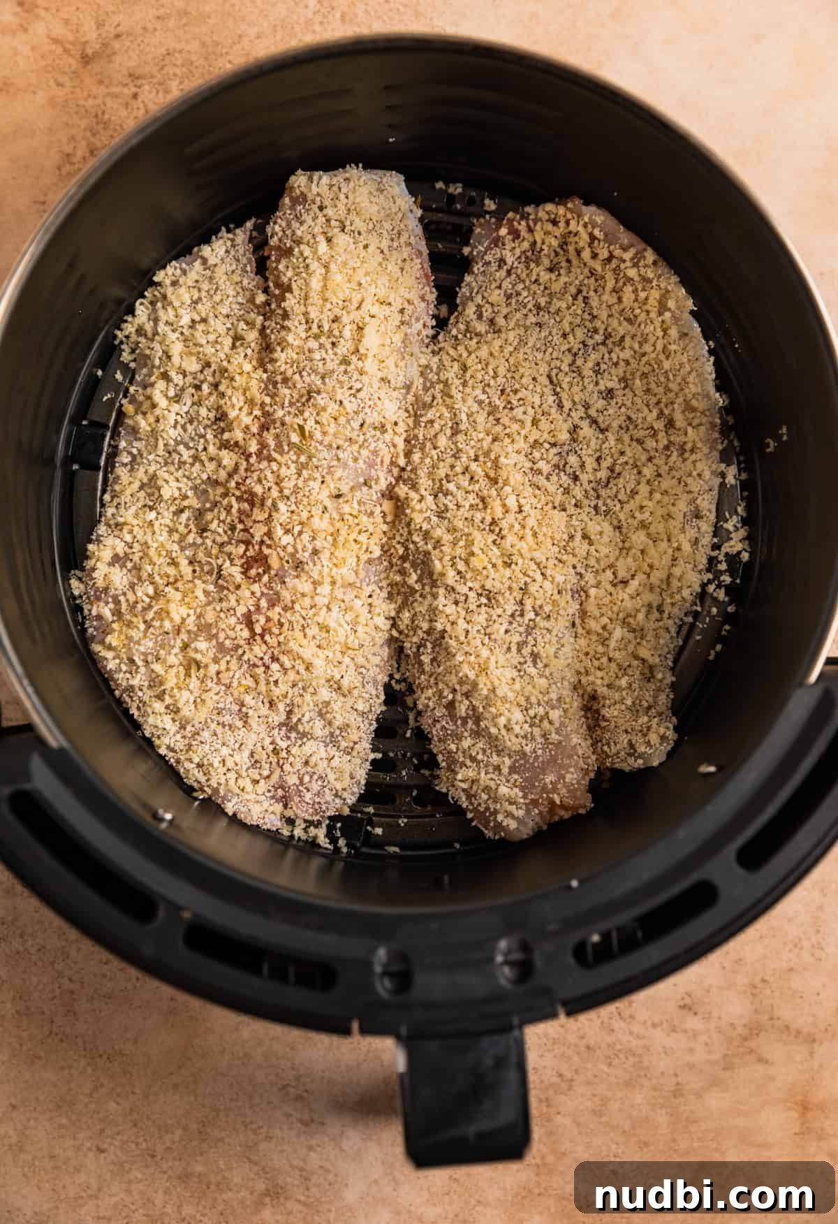 Crispy Parmesan-Crusted Tilapia in the Air Fryer 6 Parmesan crusted tilapia in air fryer basket before cooking.