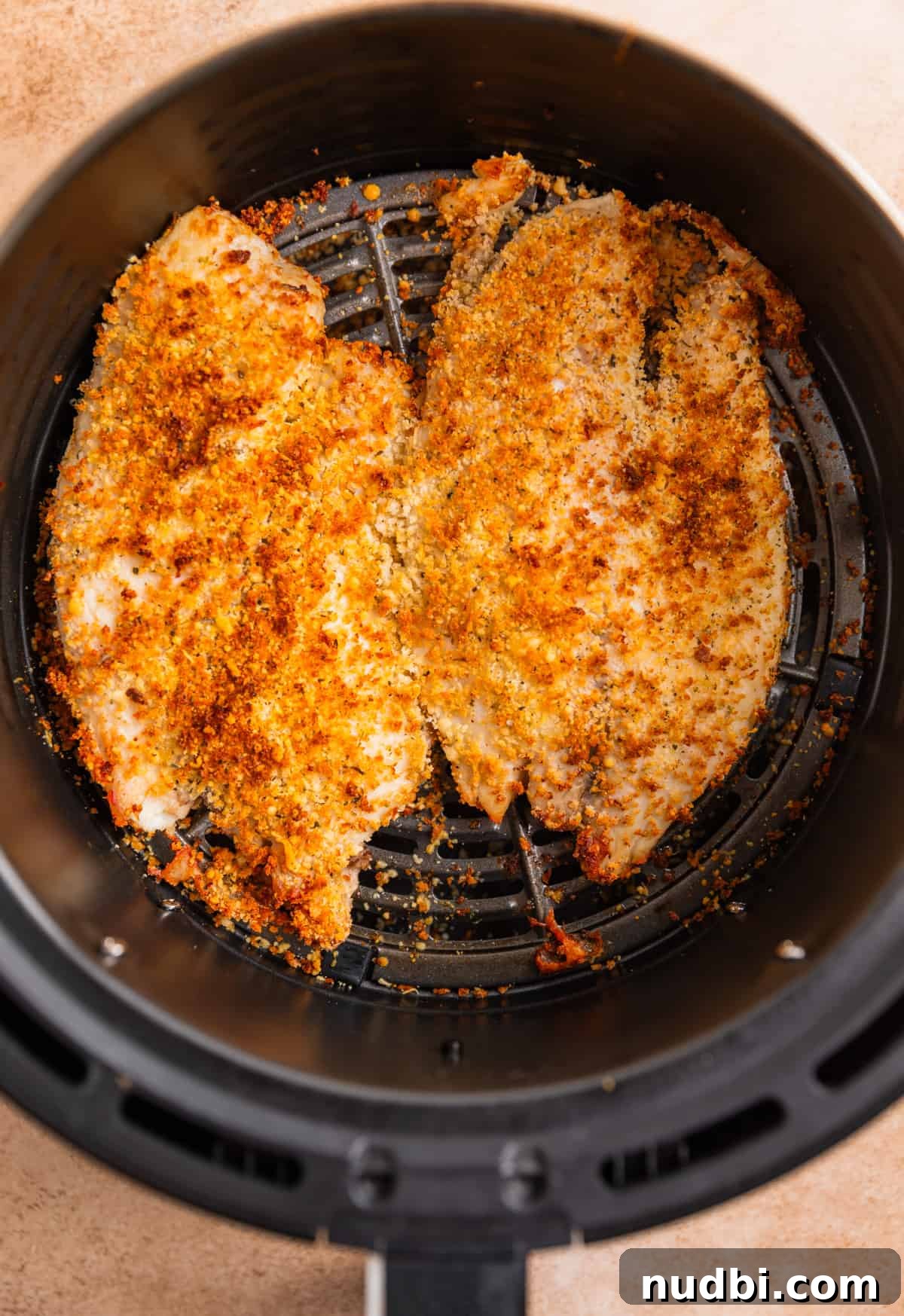 Crispy Parmesan-Crusted Tilapia in the Air Fryer 7 Parmesan crusted tilapia in air fryer basket after cooking.