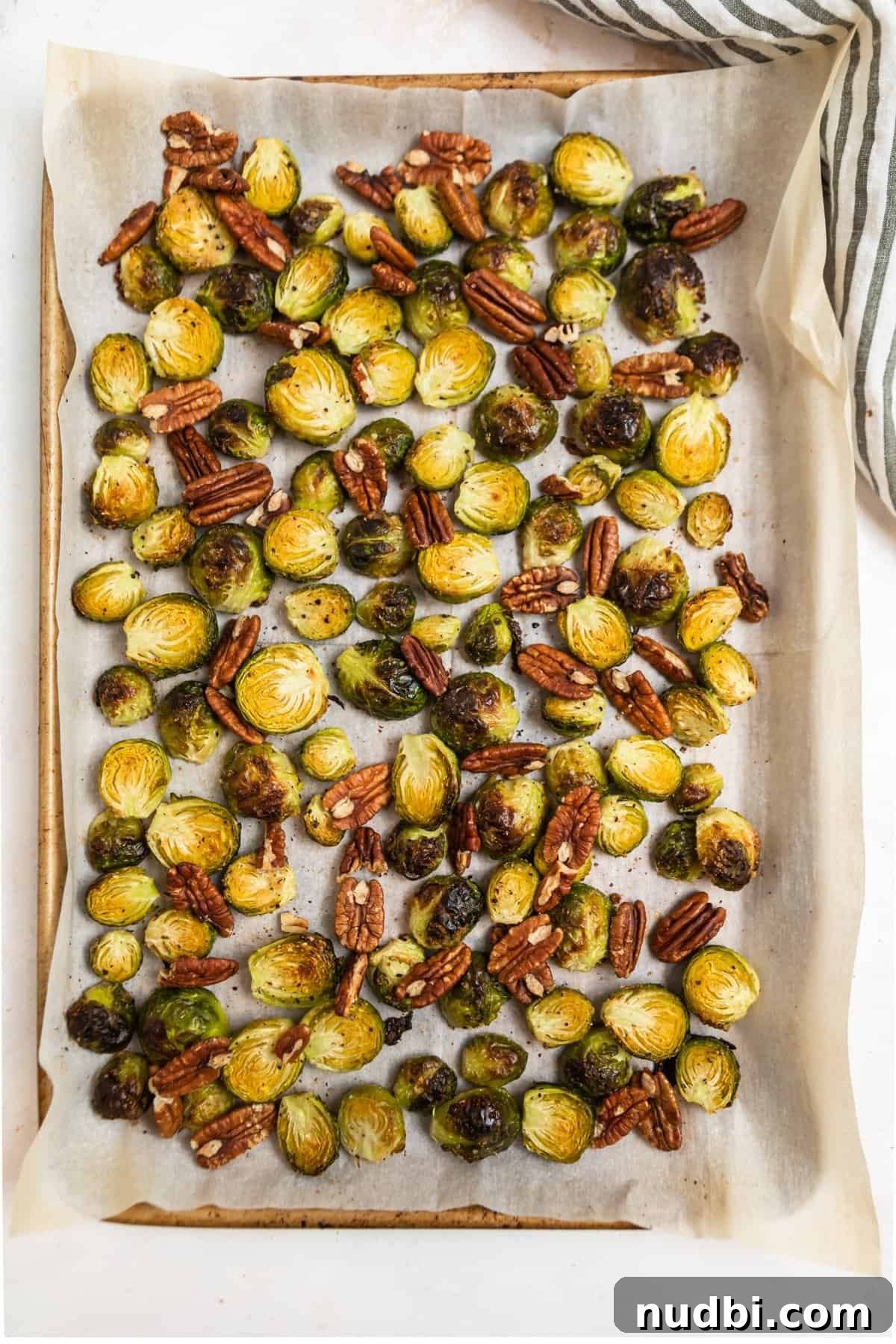 Maple Balsamic Roasted Brussels Sprouts Recipe 5 Sheet pan lined with parchment with roasted Brussels sprouts and pecans.