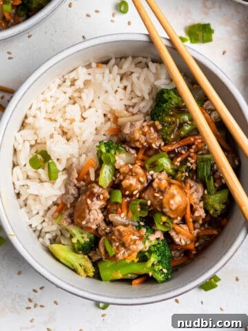 Teriyaki ground pork stir fry in bowl with white rice and chopsticks.