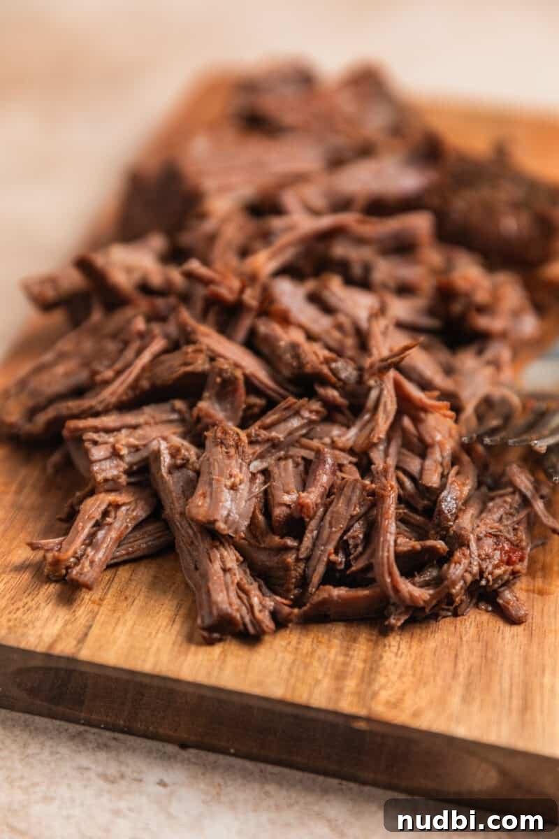 Slow Cooker Shredded Beef Chili Recipe for Comforting Weeknights 7 Shredded beef on cutting board.