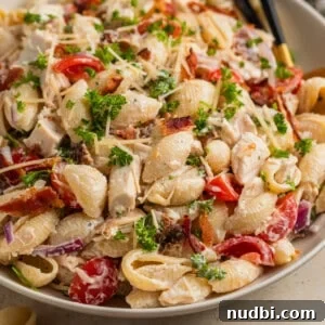 Dish with chicken bacon pasta salad and serving spoon.
