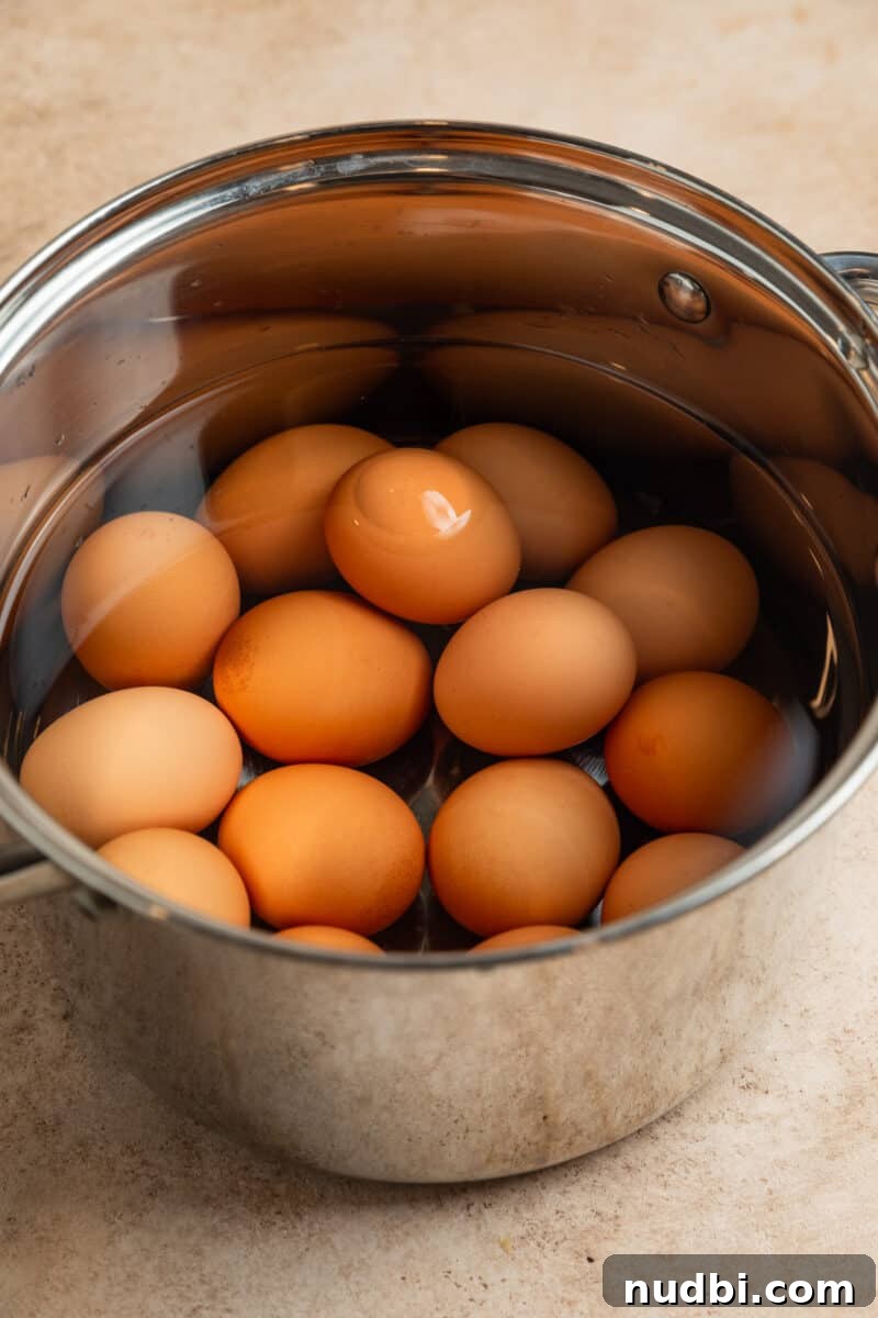 Spicy Deviled Eggs Recipe with Tangy Jalapeño Kick 4 Eggs in pot with water before boiling.