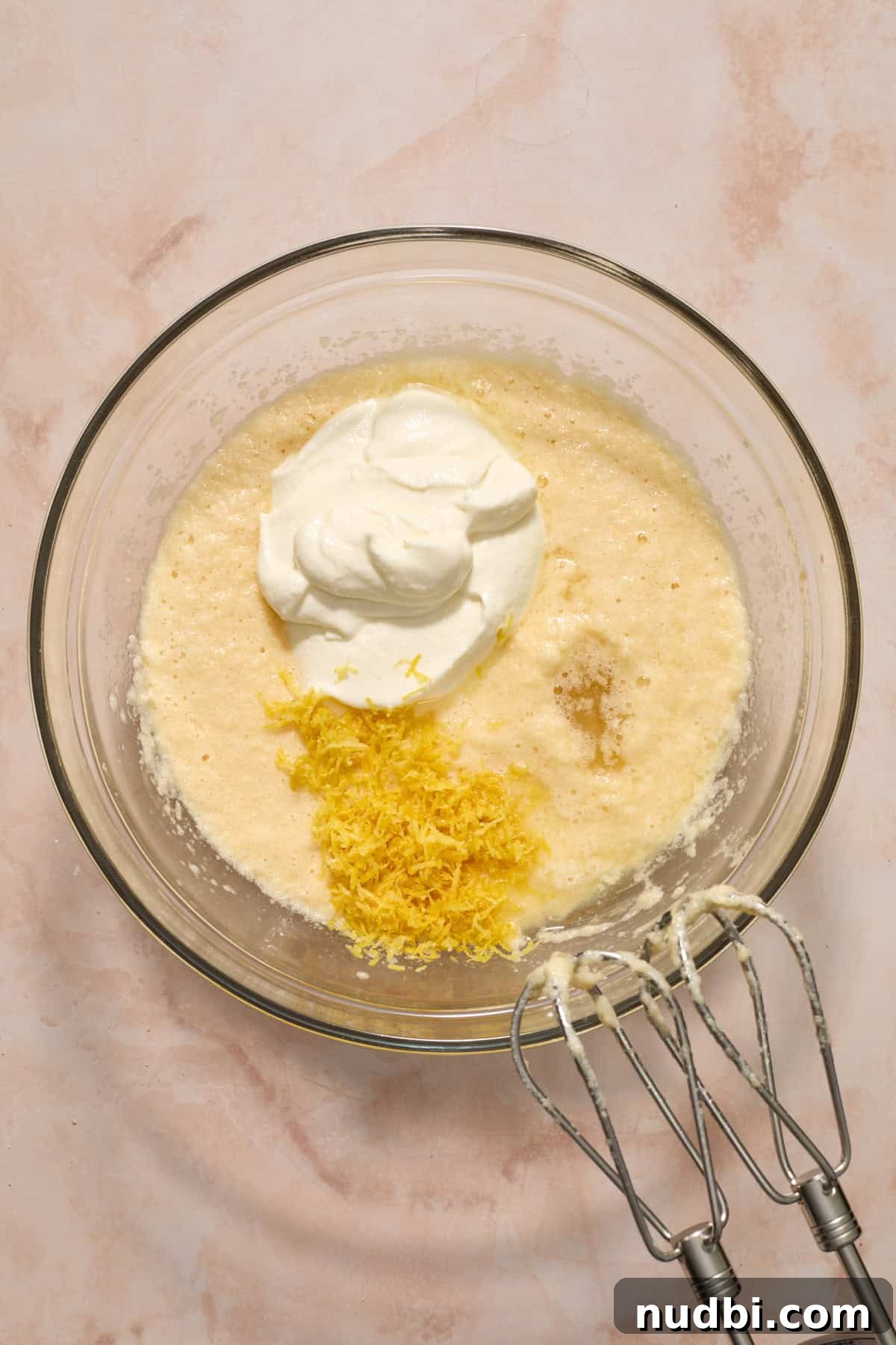 Blueberry Lemon Coffee Cake Recipe — Moist Citrus Bundt Cake 8 Sour cream, lemon zest and lemon juice added to bowl with wet ingredients.