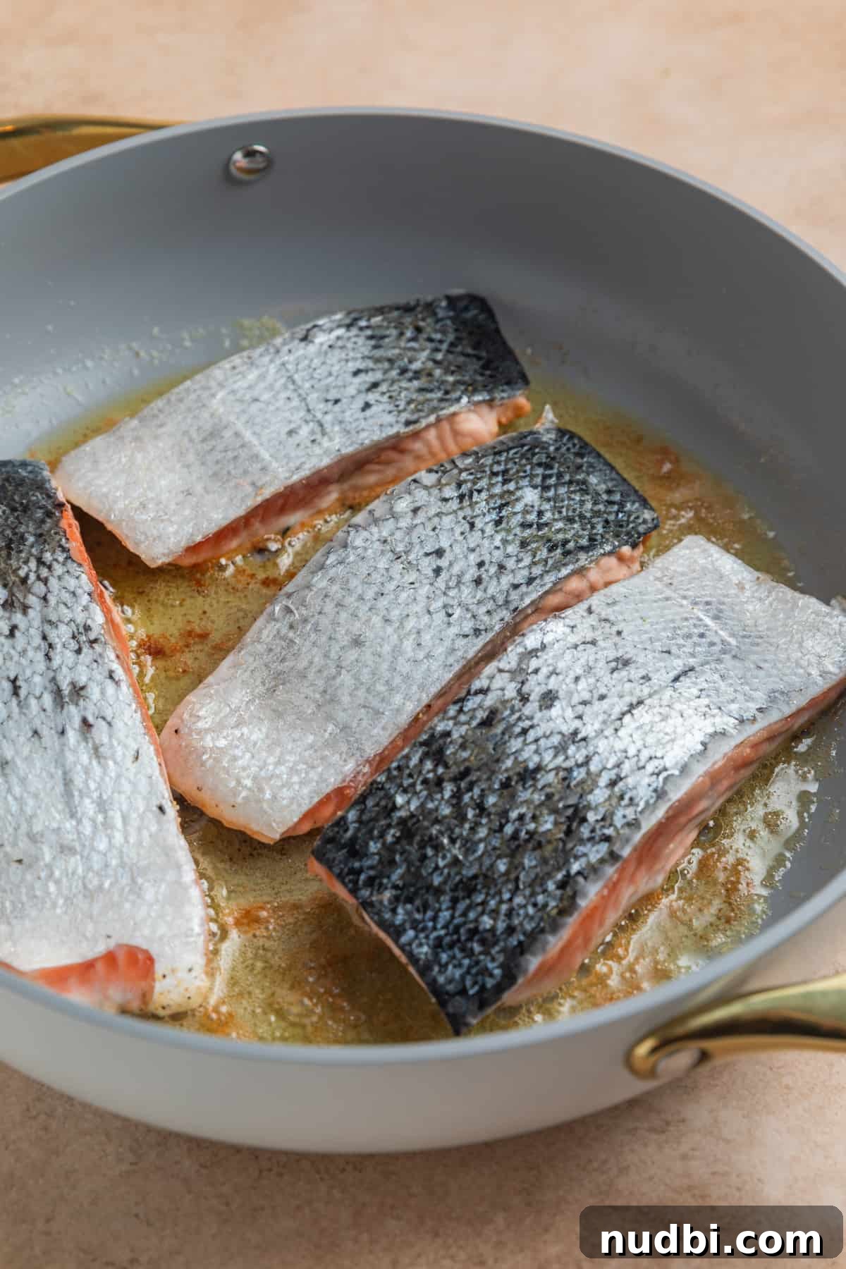 Salmon filets in skillet with skin up.