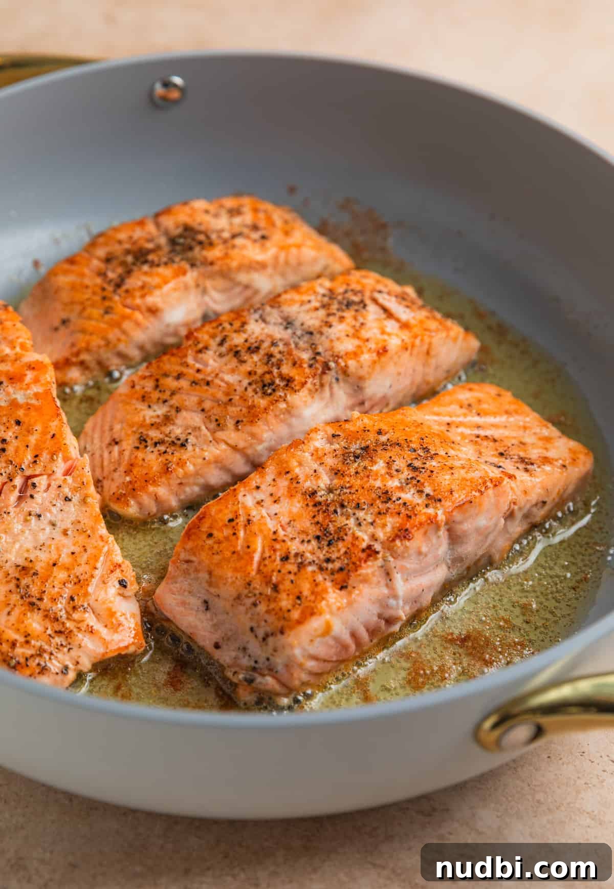 Seared salmon in skillet.