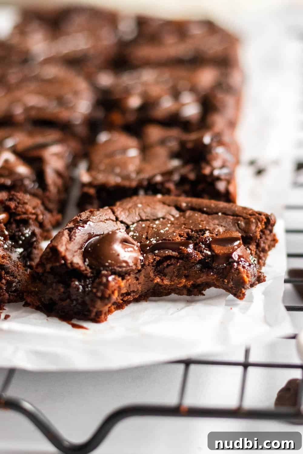 Double Chocolate Brownies Made with White Beans 5 Brownies with chocolate chips on a cooling rack.