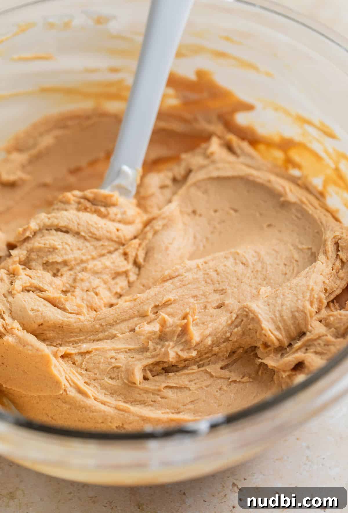 Creamy Greek Yogurt Bark Recipe with Fruit and Honey Toppings 5 Peanut butter protein yogurt mixture in glass mixing bowl with spoon.